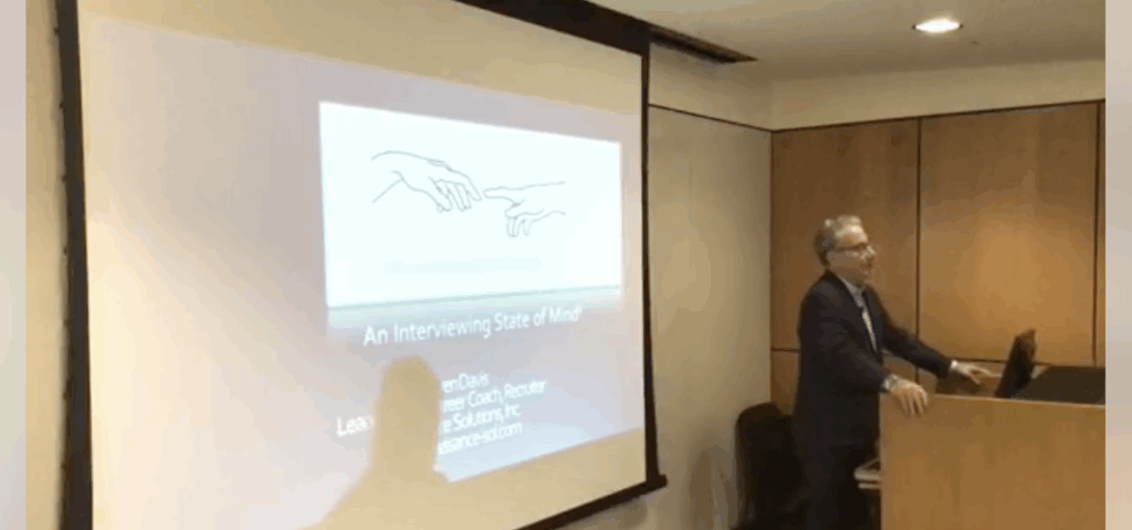 Presenter explains a slide with two hands reaching towards each other.