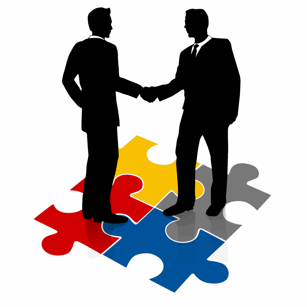 Two businesspeople shaking hands over colorful puzzle pieces.